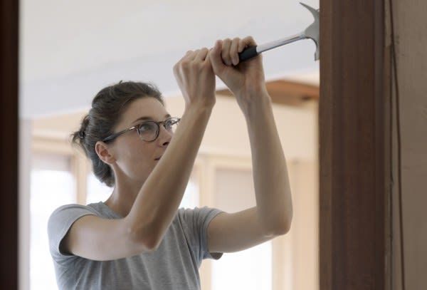 Woman removing nail on wood